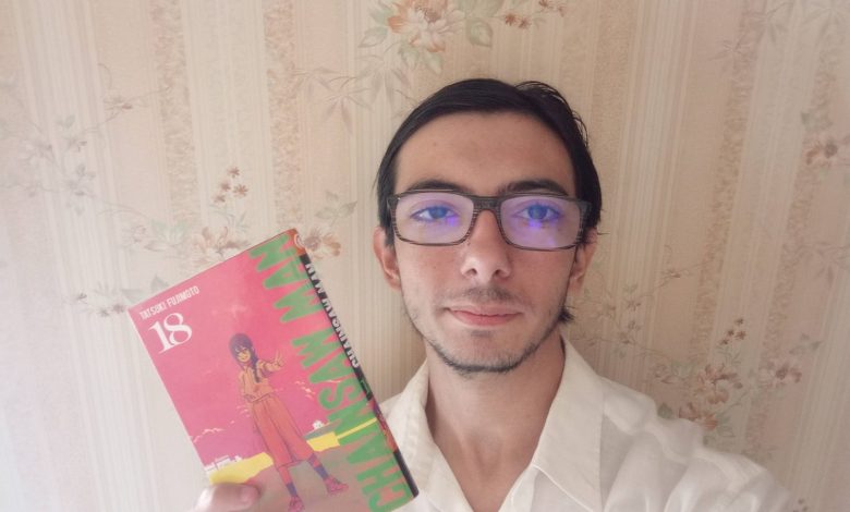 Jeune homme tenant un manga